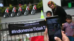 Layar ponsel menunjukkan foto warga yang tengah mengabadikan gambar di depan Menara Cakrawala, Jakarta, Sabtu (16/1). Lokasi teror di kawasan Sarinah Thamrin terus didatangi warga untuk mengabadikan diri atau foto selfie. (Liputan6.com/Faizal Fanani)