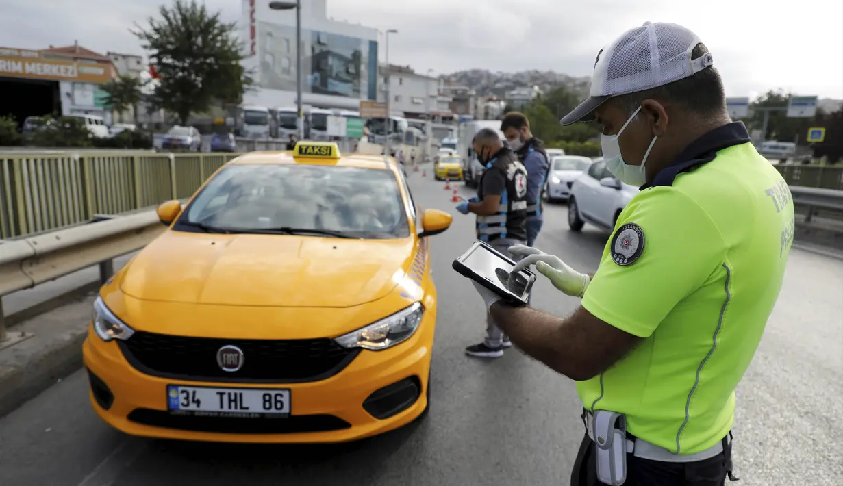 Polisi memeriksa taksi di pos pemeriksaan di Istanbul, Turki, Rabu (8/7/2020). Turki menggelar inspeksi nasional untuk mencegah penyebaran virus corona COVID-19. (Xinhua/Osman Orsal)