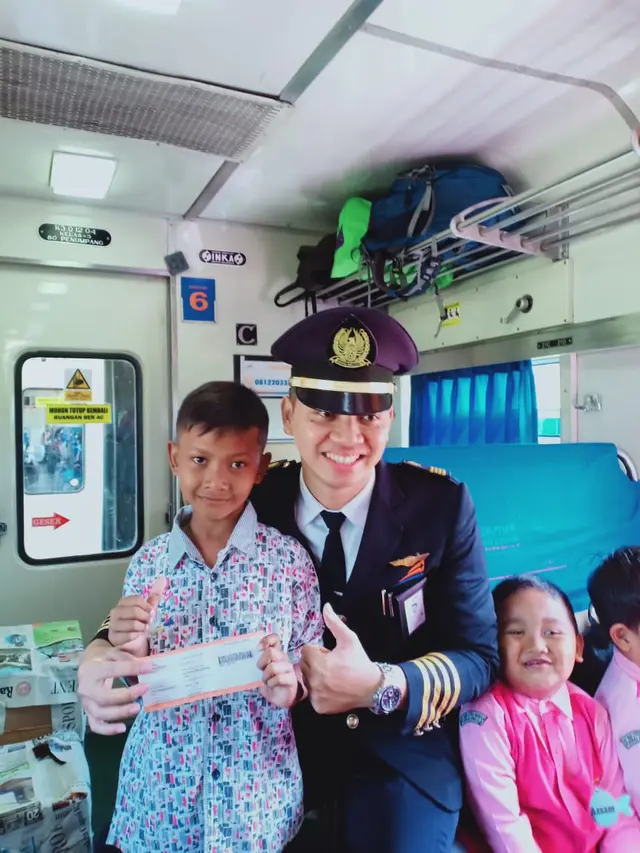 Fasha, bocah penjaga pintu rel kereta berfoto bersama dengan masinis kereta api. (Foto: Liputan6.com/Humas Daop 5/Muhamad Ridlo)