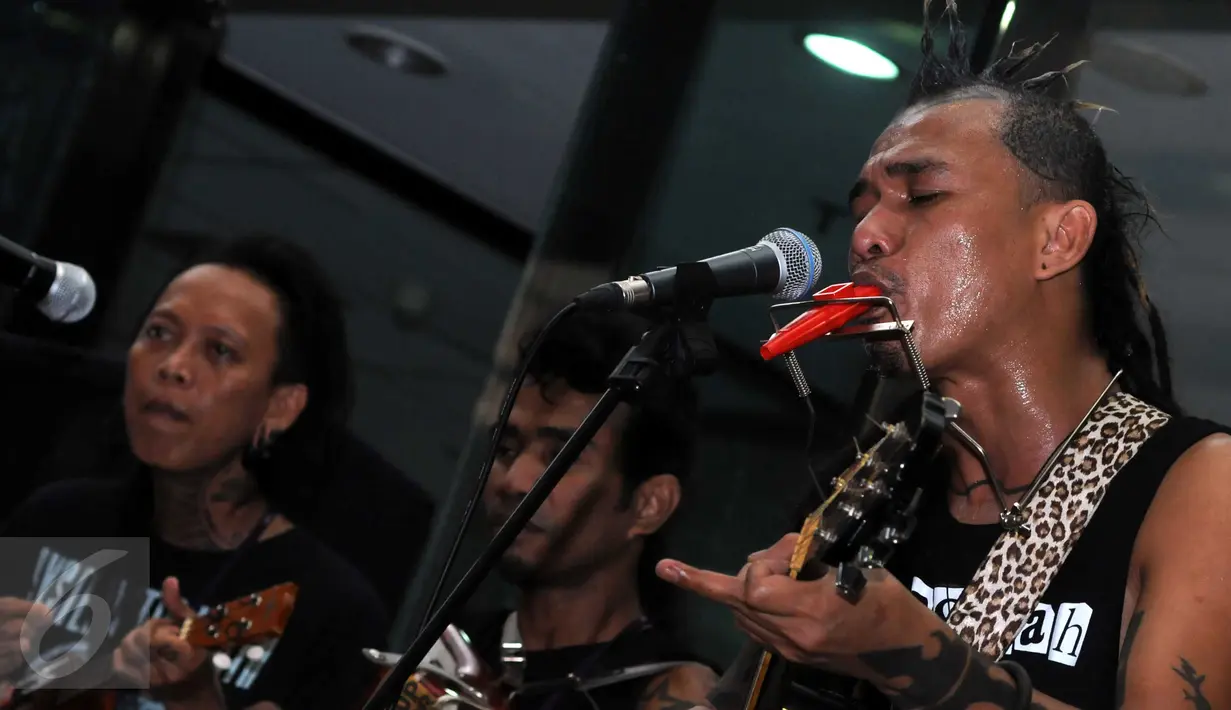 Vokalis Marjinal Mike (kanan) beraksi didepan Gedung KPK, Jakarta, Rabu (17/2). "Maling-maling kecil dihakimi, maling-maling besar dilindungi," dendang Mike saat menyanyikan lagu Hukum Rimba di Gedung KPK. (Liputan6.com/Helmi Afandi)