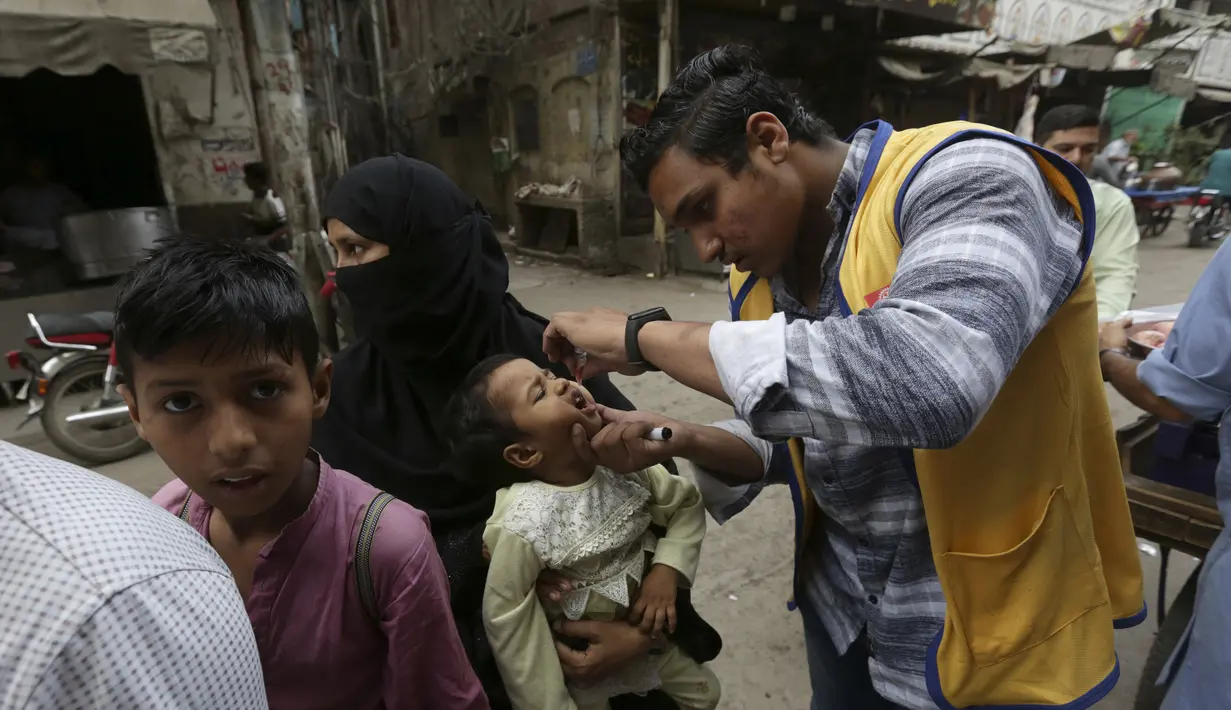 <p>Seorang petugas kesehatan memberikan tetes vaksin polio kepada anak-anak saat kampanye vaksinasi polio dari rumah ke rumah di lingkungan Lahore, Pakistan, Senin (23/5/2022). Pakistan meluncurkan upaya anti-polio baru pada hari Senin, lebih dari seminggu setelah pejabat mendeteksi kasus ketiga tahun ini di wilayah barat laut negara itu yang berbatasan dengan Afghanistan. (AP Photo/K.M. Chaudary)</p>