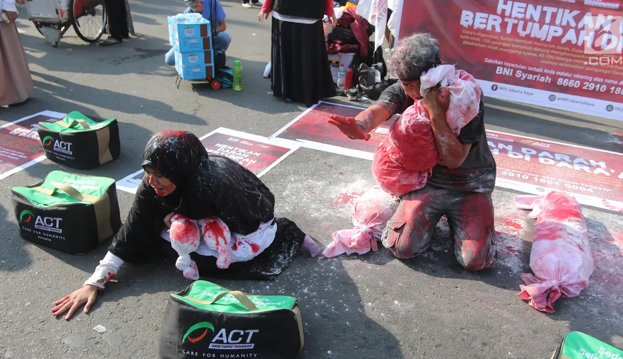 Dua relawan dari Aksi Cepat Tanggap (ACT) saat melakukan teatrikal tentang penderita rakyat Suriah yang menjadi korban peperangan di CFD Bundaran HI, Jakarta, Minggu (15/7). (Liputan6.com/Arya Manggala)
