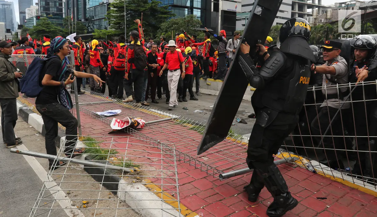 Pewarta foto mengamati pagar besi di pelican crossing Tosari yang roboh saat peringatan Hari Buruh 2019 di kawasan Sudirman dekat Bundaran HI, Jakarta, Rabu (1/5/2019). Pagar itu roboh terimbas aksi dorong buruh dan polisi yang menahan agar massa tidak menuju Bundaran HI. (Liputan6.com/Johan Tallo)