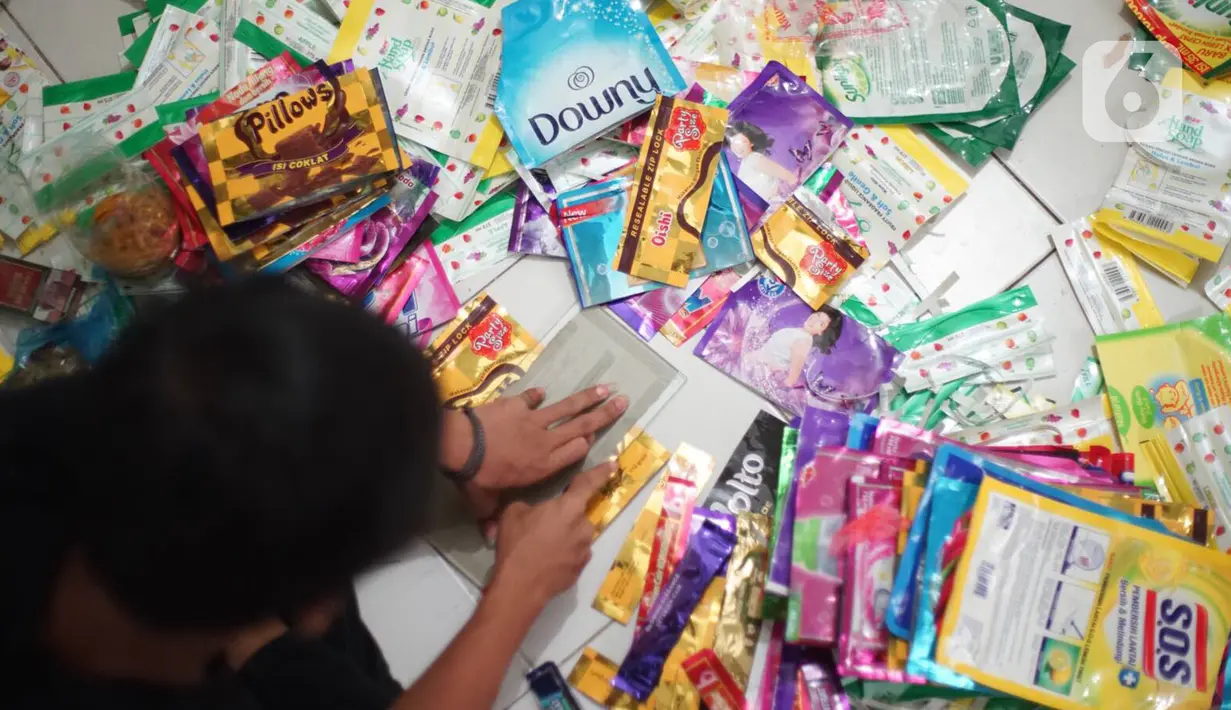 Pekerja memotong sampah plastik di rumah produksi di kawasan Pasar Minggu, Jakarta, Senin (13/1/2020). Rumah daur ulang plastik itu memproduksi barang dari limbah plastik seperti tas, payung, dompet, dan koper dengan harga jual berkisar Rp20ribu hingga Rp700ribu. (Liputan6.com/Immanuel Antonius)