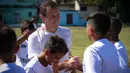Emilio Butragueno menyalami anak-anak dari Real Madrid Foundation usai memberikan pelatihan sepak bola. (AFP/Yamil Lage)