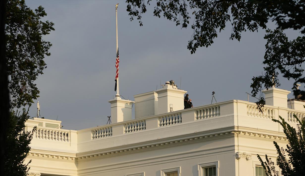 Pekerja berjalan di atap Gedung Putih di Washington, Kamis (26/8/2021). Semua gedung federal dan fasilitas militer milik AS akan mengibarkan bendera AS setengah tiang untuk menghormati anggota marinir AS dan lainnya yang tewas dalam serangan bom di Kabul, Afghanistan. (AP Photo/Susan Walsh)