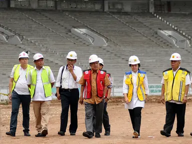 Wakil Presiden, Jusuf Kalla (tengah) berjalan melihat proyek renovasi Stadion Gelora Bung Karno, Jakarta, Minggu (26/3). Peninjauan ini terkait persiapan pelaksanaan Asian Games 2018 mendatang. (Liputan6.com/Helmi Fithriansyah)