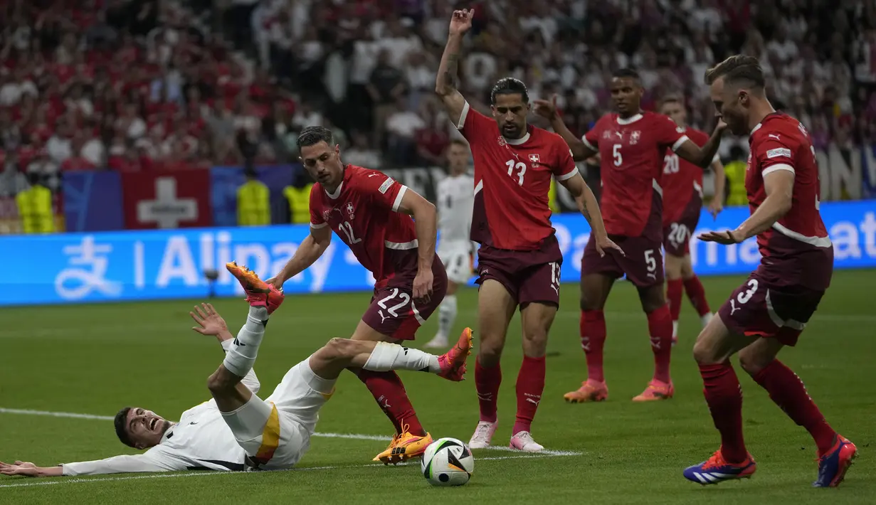 Striker Timnas Jerman, Kai Havertz (kiri) terjatuh usai perebutan bola dengan bek Timnas Swiss, Fabian Schar pada laga matchday ketiga Grup A Euro 2024 di Waldstadion, Frankfurt, Jerman, Minggu (23/6/2024). (AP Photo/Darko Vojinovic)