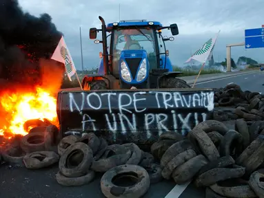 Para petani Perancis memblokir salah satu ruas jalan utama di Seclin, Perancis, Rabu (22/7/2015). Petani Perancis memprotes karena belum mendapatkan keuntungan dari kenaikan harga daging dan susu yang dijual di pasaran. (REUTERS/Pascal Rossignol)