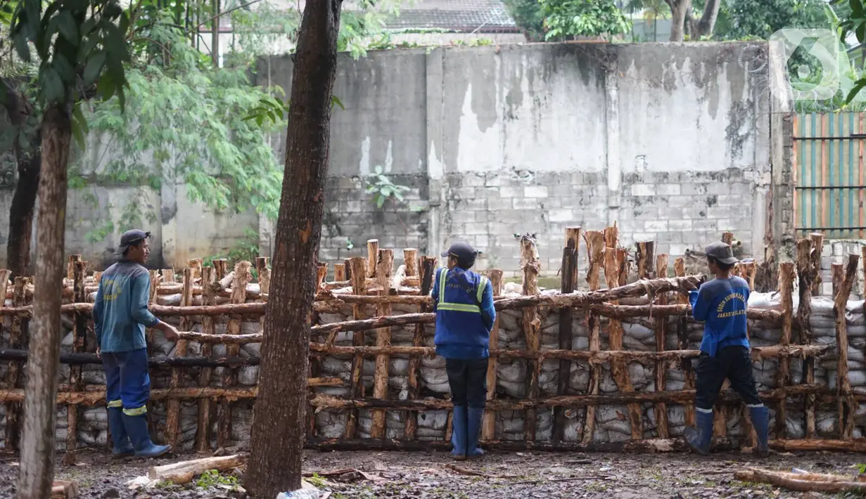 Petugas Sudin SDA Jakarta Selatan memperbaiki tanggul Kali Krukut yang jebol di Jalan Perumahan Kemang Jaya, Bangka, Jakarta, Rabu (8/1/2020). Tanggul jebol akibat tak kuat menahan derasnya air kiriman dari hulu serta hujan deras yang mengguyur kawasan tersebut. (Liputan6.com/Immanuel Antonius)