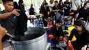 Relawan mewarnai pakaian pelayat agar menjadi hitam untuk dikenakan selama masa berkabung atas wafatnya raja Thailand Bhumibol Adulyadej di Grand Palace di Bangkok, Thailand (17/10). Relawan ini mewarnai pakaian warga secara suka rela.(Reuters/Edgar Su)