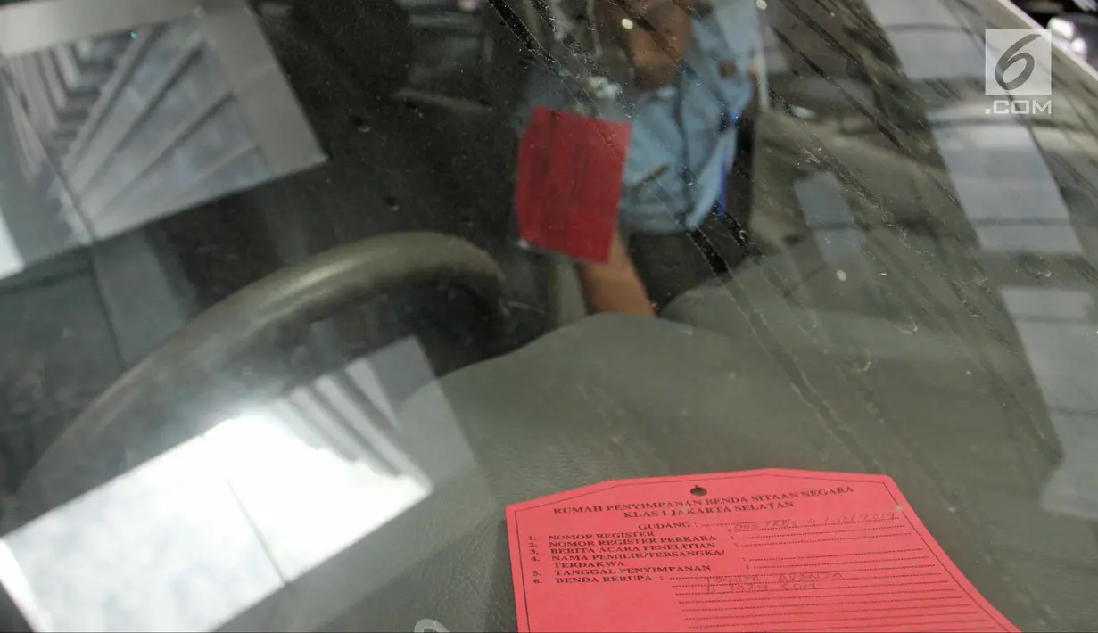 Petugas Rumah Penyimpanan Benda Sitaan Negara (Rupbasan) Jakarta Utara mengecek kondisi mobil sitaan di Gedung Komisi Pemberantasan Korupsi (KPK), Jakarta, Selasa (30/1). (Liputan6.com/Herman Zakharia)