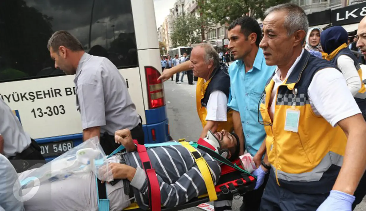 Petugas medis mengevakuasi korban luka akibat sebuah bus menabrak halte yang penuh penumpang di distrik Dikimevi, Ankara, Turki, Kamis (1/10/2015). 12 orang tewas akibat bus kehilangan kendali karena mengalami rem blong. (AFP PHOTO/ADEM ALTAN)