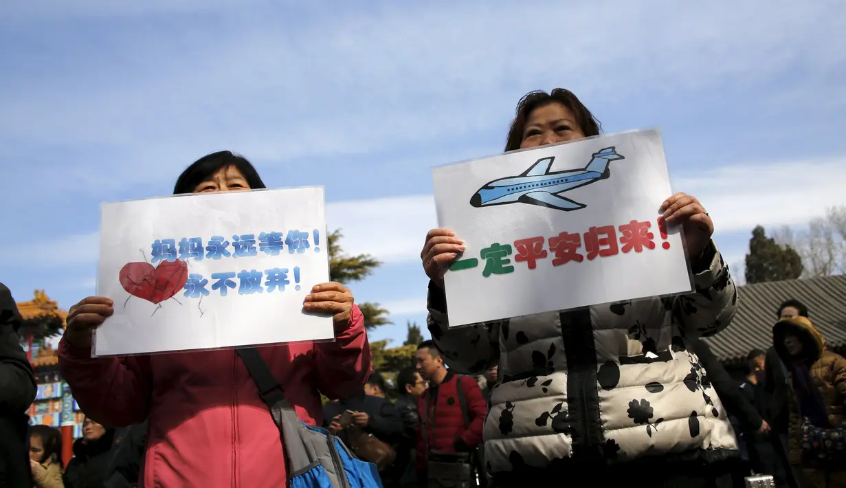 Anggota keluarga penumpang pesawat Malaysia Airlines MH370 berunjuk rasa membawa poster di Lama Temple, Beijing, Cina, (8/3). Poster Tersebut bertuliskan "Ibu akan selalu menunggu. Tidak akan menyerah." (REUTERS/Kim Kyung-hoon)