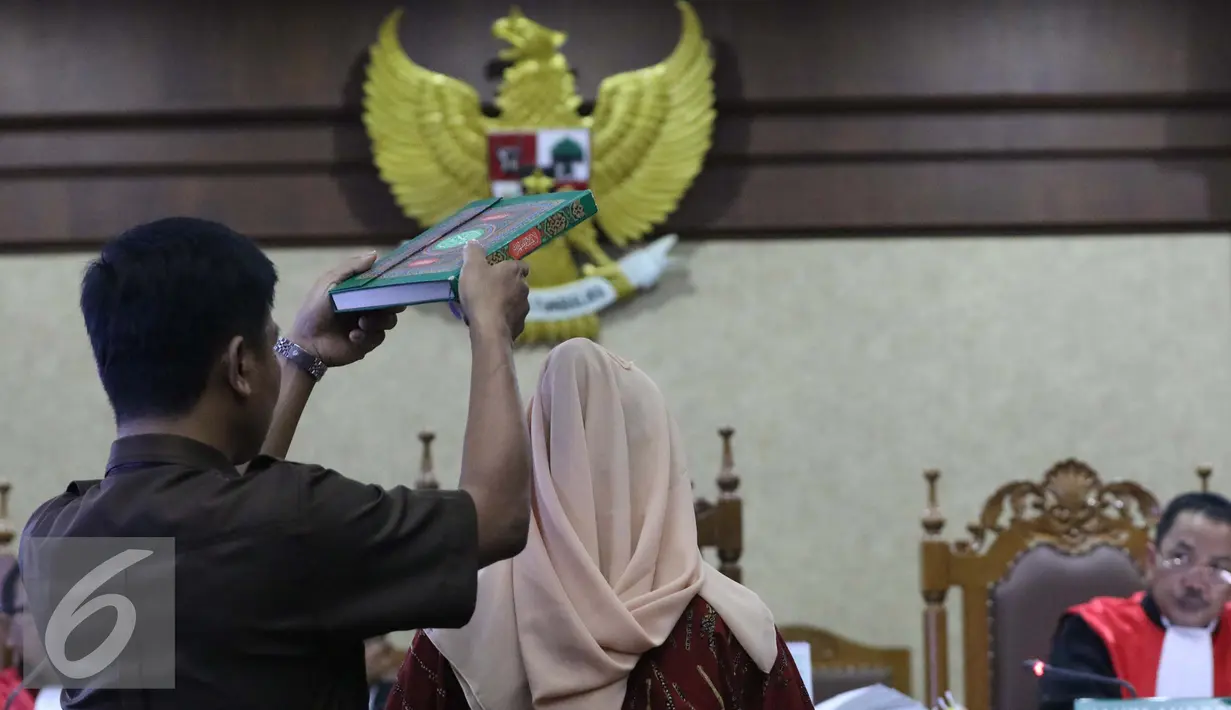 Ahli Hukum Pidana dan Kriminolog UI, Eva Achjani Zulfa disumpah jelang memberi kesaksian dalam sidang ke-22, kasus kematian Mirna Wayan Salihin di Pengadilan Negeri Jakarta Pusat, Jakarta, Senin (19/9). (Liputan6.com/Helmi Afandi)