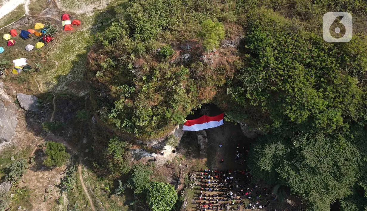 Foto udara upacara pengibaran bendera Merah Putih pada HUT ke-78 RI di lokasi bekas tambang batu kapur Tebing Arpam, Gua Sigugula Karst Klapanunggal, Kabupaten Bogor, Jawa Barat, Kamis (17/8/2023).  (merdeka.com/Imam Buhori)