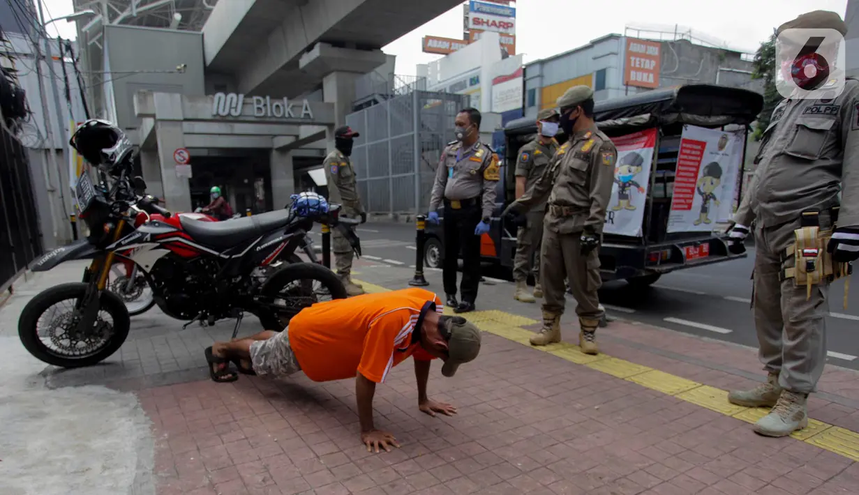 Petugas gabungan memberikan hukuman push up kepada warga yang tidak memakai masker saat razia Pembatasan Sosial Berskala Besar (PSBB) di Kawasan Jalan Fatmawati, Jakarta, Selasa (28/4/2020). Penertiban terkait pelaksanaan PSBB Jakarta dan memutus rantai penyebaran COVID 19. (merdeka.com/Imam Buhori)