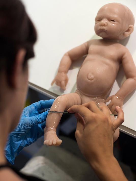 Pekerja menyelesaikan pembuatan boneka bayi silikon yang mirip manusia di Clon Factory, Spanyol Basque, Selasa (20/6). Pabrik ini khusus memproduksi bayi imitasi dari premium silikon yang biasa dipakai untuk operasi plastik. (ANDER GILLENEA/AFP)