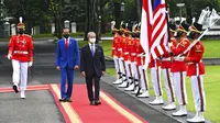 Presiden Indonesia Joko Widodo (kedua kiri) berjalan dengan Perdana Menteri Malaysia Muhyiddin Yassin saat mereka memeriksa penjaga kehormatan dalam pertemuan di Istana Merdeka, Jakarta, Jumat (5/2/2021). Muhyiddin Yasin tiba sekira pukul 10.30 WIB. (Agus Suparto, Indonesian President Palace via AP)