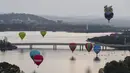 Sejumlah balon udara terbang bebas diatas danau Burley Griffin, Canberra,  Australia, (15/3). Ini dilakukan dilakukan dalam memperingati ulang tahun ke-30 festival Balloon Spectacular Canberra . (REUTERS / Lukas Coch)