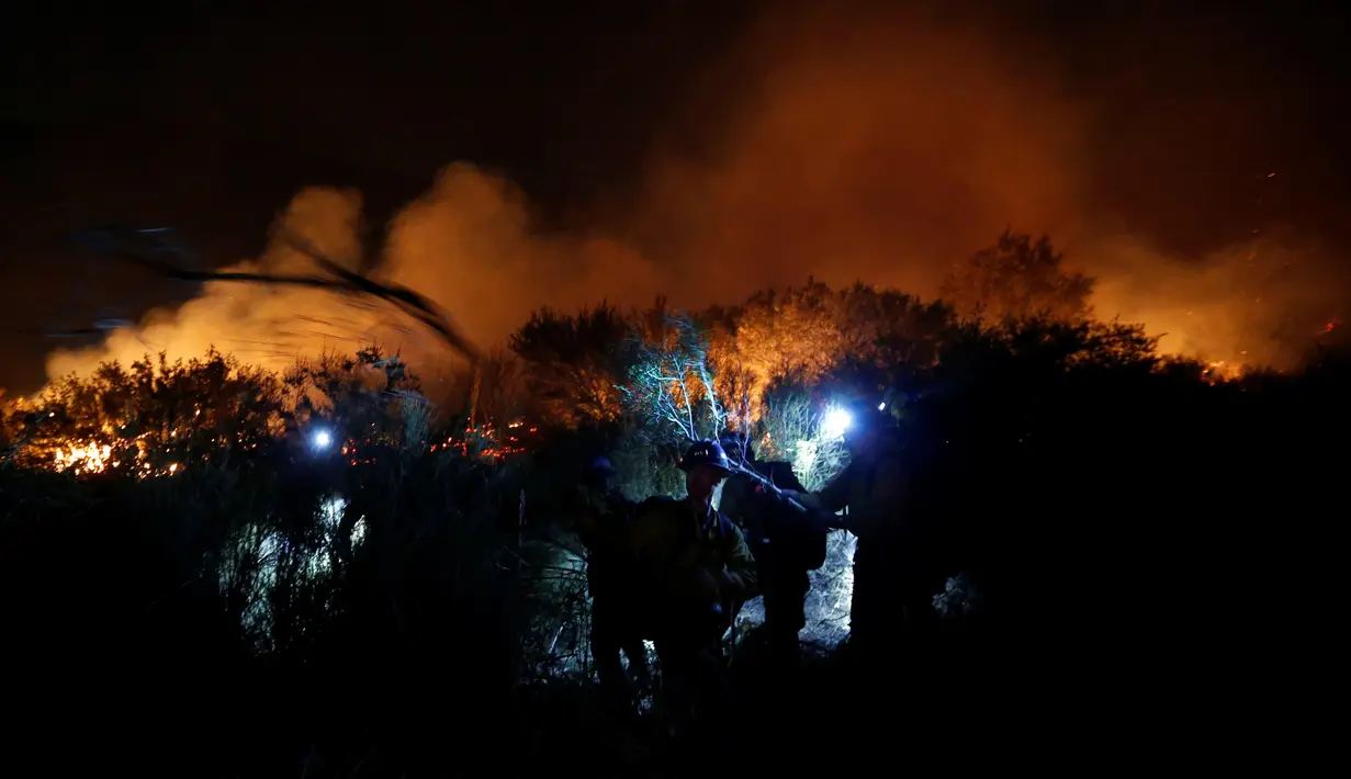 Petugas pemadam kebakaran membangun jalur api saat kebakaran hutan di California, Amerika Serikat, (17/08). Keadaan darurat diberlakukan di San Bernardino County, berjarak hanya 60 mil (100 kilometer) timur dari Los Angeles. (REUTERS/Patrick T Fallon)