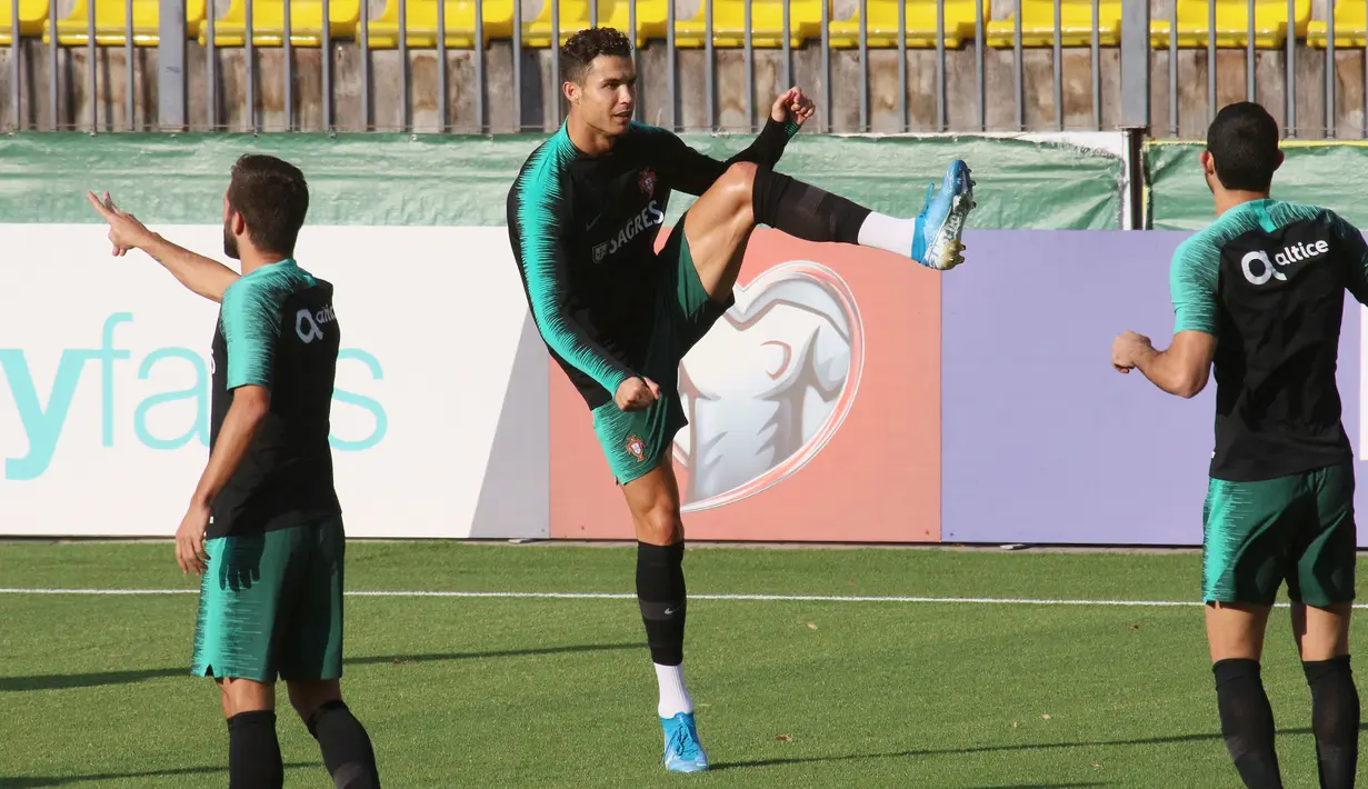 Penyerang Portugal, Cristiano Ronaldo (tengah) melakukan pemanasan dalam sesi latihan di Vilnius, Lithuania (9/9/2019). Portugal akan bertanding melawan Lithuania pada grup B Kualifikasi Euro 2020. (AFP Photo/Petras Malukas)