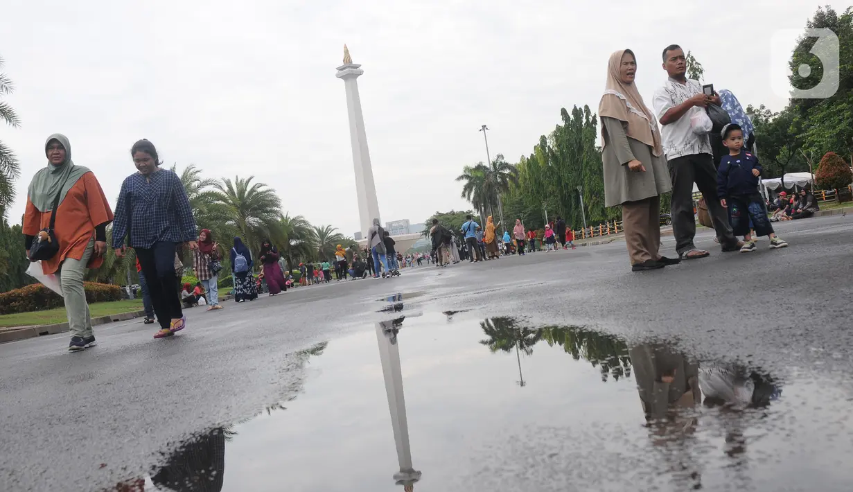 Warga berjalan-jalan di kawasan Monumen Nasional, Jakarta, Rabu (25/12/2019). Libur perayaan Natal 2019 dimanfaatkan warga Jakarta dan sekitarnya berwisata di Monumen Nasional. (Liputan6.com/Helmi Fithriansyah)