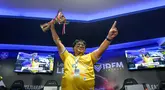 Atlet E-Sports Indonesia, Syamsul Arip mengangkat piala setelah menjuarai Lenovo Legion IDFM 2025 nan berjalan di Sentinel Cyber Arena, Jakarta Timur, Minggu (23/02/2025). (carpet-cleaning-kingston.co.uk/Bagaskara Lazuardi)