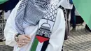 Ia tampak mengenakan kafayeh dan gamis putih. Tak ketinggana syal dengan aksen bendera Palestina menjadi pernyataan gayanya. [Instagram/ ShellaSaukia]