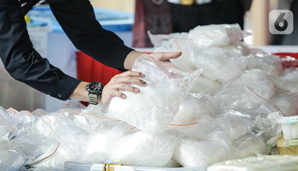 Polisi merapikan barang bukti sabu saat konferensi pers di Mabes Polri, Jakarta, Rabu (28/4/2021). Barang bukti sebanyak itu didapatkan dari penindakan dari sejumlah tempat. Dalam kasus ini, Satgas Polri menangkap total 18 tersangka, terdiri dari 17 WNI dan 1 WN Nigeria. (Liputan6.com/Faizal Fanani)