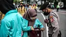 Polisi memeriksa barang bawaan mahasiswa yang akan berunjuk rasa di Patung Kuda, Jakarta, Selasa (20/10/2020). Pemeriksaan tersebut dilakukan untuk memastikan unjuk rasa berjalan aman dan damai. (Liputan6.com/Faizal Fanani)