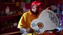 Pengrajin Salvador Meza menyelasaikan pembuatan replika gitar dari film "Coco" di rumah produksinya di Paracho, Meksiko (8/1). Kerena film animasi Coco pengrajin di Meksiko dibanjiri pesanan gitar yang mirip di film tersebut. (AFP Photo/ Ronaldo Schemidt)