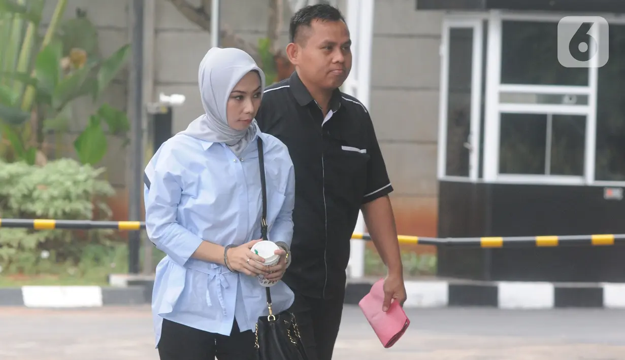 Terpidana General Manager Commercial PT Humpuss Transportasi Kimia, Asty Winasti dikawal petugas berjalan masuk akan menjalani pemeriksaan sebagai saksi di Gedung KPK, Jakarta, Selasa (12/11/2019). (merdeka.com/Dwi Narwoko)
