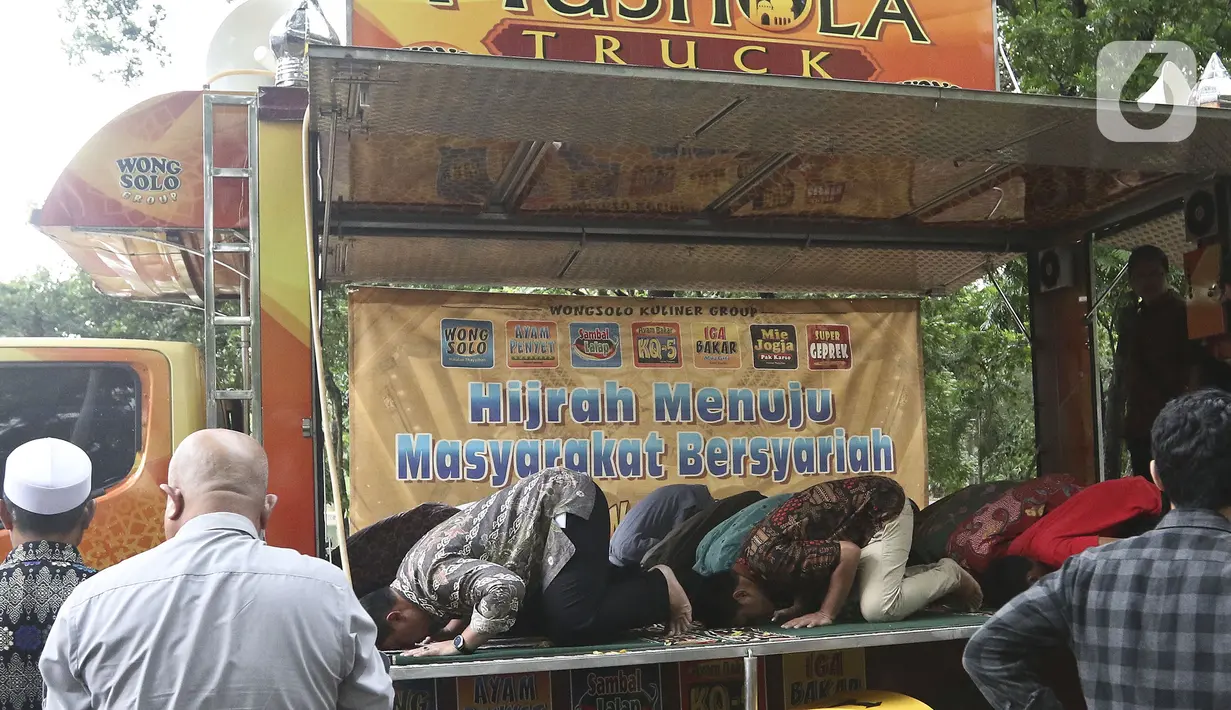 Jamaah melaksanakan ibadah salat di Musala Truck Al-Hijrah di kawasan Universitas Indonesia, Depok, Jawa Barat, Sabtu (1/2/2020). Biasanya modifikasi truck kita lihat sebagai food truck atau toilet namun uniknya truck ini dijadikan tempat beribadah atau musala. (Liputan6.com/Johan Tallo)