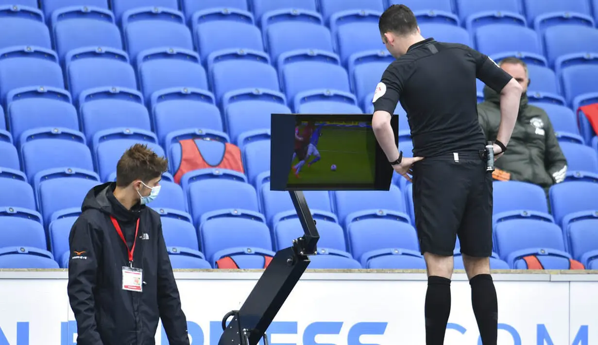 Wasit Chris Kavanagh melihat layar VAR saat Manchester United melawan Brighton Hove Albion pada laga Liga Inggris, Sabtu (26/9/2020). Setan Merah menang dengan skor 3-2. (Glyn Kirk/Pool via AP)