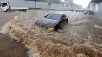 Mobil menerjang banjir yang menggenangi Jalan Tol JORR di kawasan TB Simatupang, Jakarta Selatan, Sabtu (20/2/2021). Banjir terjadi akibat luapan Kali Serua yang berada di pinggir jalan tol. (merdeka.com/Arie Basuki)