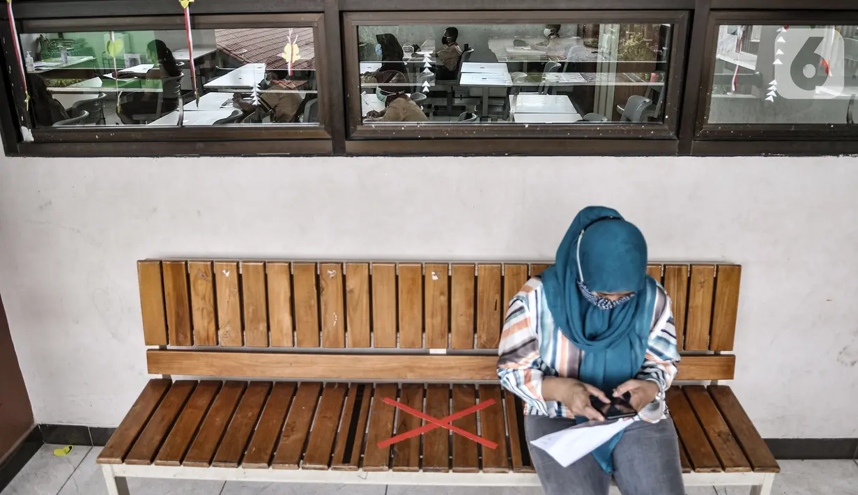 Guru berjaga di depan kelas saat berlangsungnya pembelajaran tatap muka di salah satu ruang kelas SDN Pulogadung 07, Jakarta, Rabu (7/4/2021). Pembelajaran tatap muka di DKI Jakarta dimulai pada 7-29 April. (merdeka.com/Iqbal S. Nugroho)
