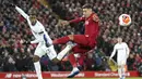Penyerang Liverpool, Roberto Firmino, berusaha menghadang tendangan pemain West Ham United, Issa Diop, pada laga Premier League di Stadion Anfield, Inggris, Selasa (25/2/2020). Liverpool menang dengan skor 3-2. (AP/Jon Super)