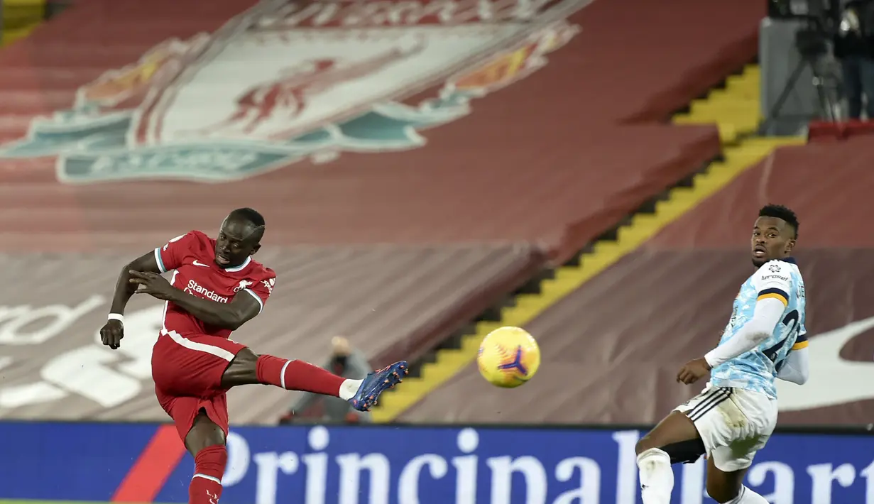 Penyerang Liverpool, Sadio Mane menembak bola saat bertanding melawan Wolverhampton Wanderers pada pertandingan lanjutan Liga Inggris di Stadion Anfield, Inggris, Minggu (7/12/2020).  Liverpool menang telak atas Wolverhampton 4-0. (Peter Powell/Pool via AP)