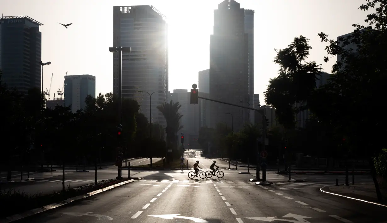 Orang-orang bersepeda di jalan bebas mobil selama hari libur Yahudi Yom Kippur, di Tel Aviv, Israel, Senin(28/9/2020). Liburan khusyuk yang setiap tahun melihat kehidupan dan keramaian di Israel akan terhenti, kali ini berlangsung di tengah lockdown selama tiga minggu. (AP Photo/Oded Balilty)