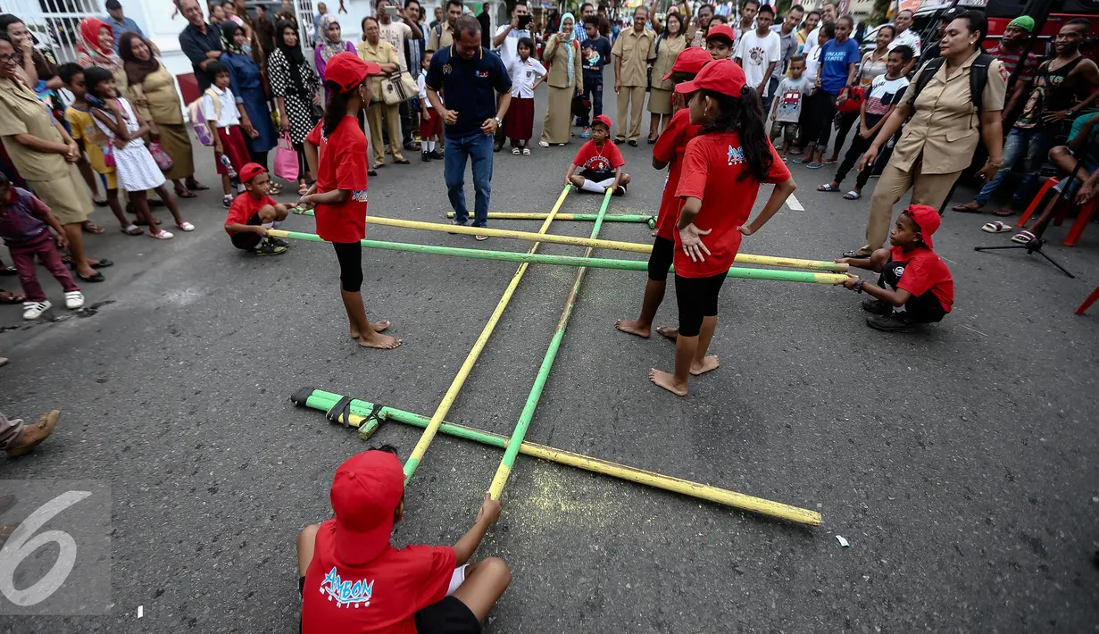 Sejumlah murid sekolah dasar bermain permain daerah dalam festival permainan tradisional rakyat Maluku didepan Balai Kota Ambon, Maluku, Selasa (7/2). Festival tersebut diselenggarakan untuk memperingati Hari Pers Nasional. (Liputan6.com/Faizal Fanani)