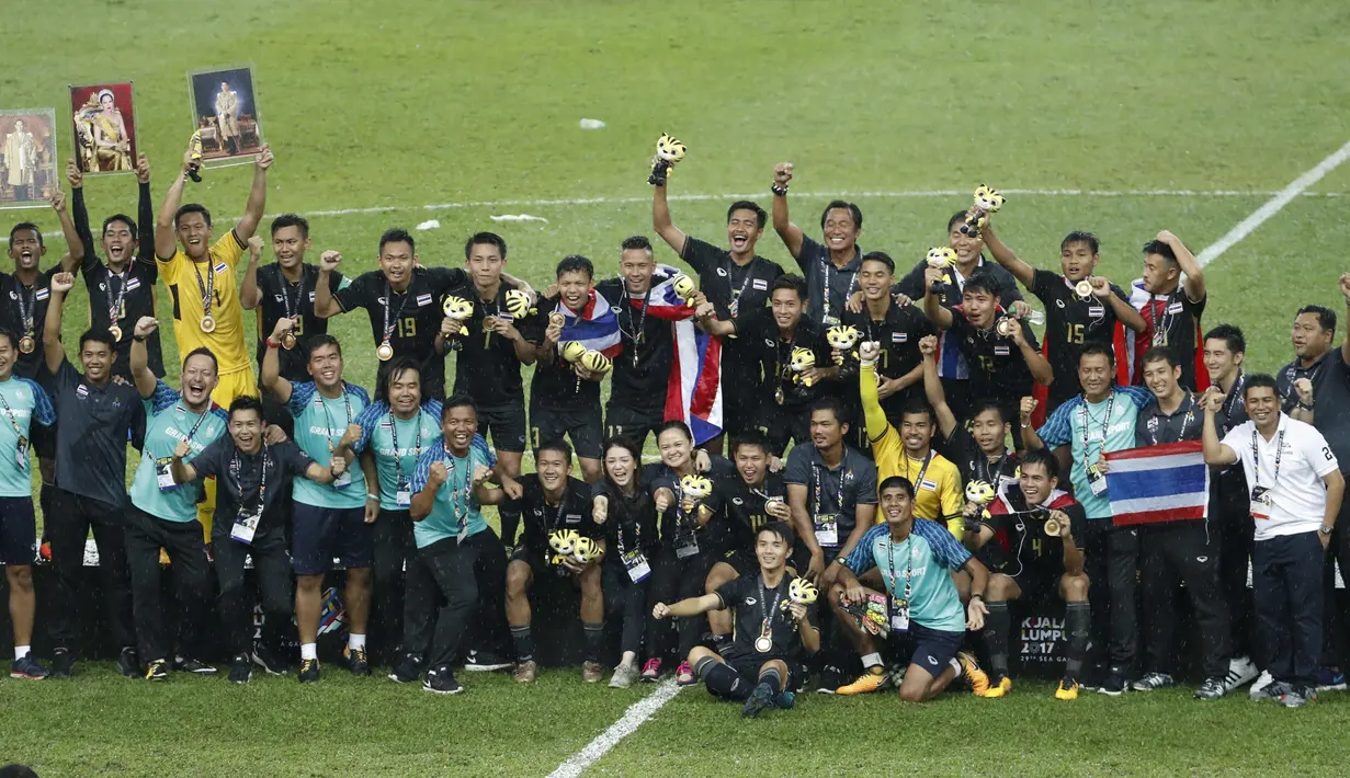 Para pemain dan offficial Thailand merayakan kemenangan atas Malaysia sekaligus meraih medali emas  pada final sepak bola putra SEA Games 2017 di Stadion Shah Alam, Malaysia (29/8/2017). Thailand menang 1-0. (AP/Vincent Thian)
