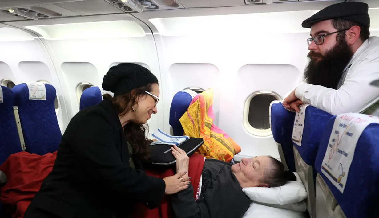 Pengungsi Yahudi Ukraina dan imigran baru dengan kesehatan buruk yang melarikan diri dari perang di negara mereka menunggu untuk turun dari pesawat setibanya di Bandara Ben Gurion, Tel Aviv, Israel, 22 Desember 2022. Sebanyak 100 orang Yahudi Ukraina tiba di Israel, termasuk beberapa penumpang yang terbaring di tempat tidur dan dalam kondisi sakit. (GIL COHEN-MAGEN/AFP)