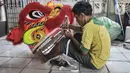 Pekerja saat menyelesaikan pembuatan Liong dan Barongsai di kawasan Babakan Pasar, Bogor, Jawa Barat, Senin (17/1/2022). Barongsai dibanderol dengan harga jual mulai Rp5 juta per buah sementara liong dihargai mulai Rp8 juta per buah. (merdeka.com/Iqbal S Nugroho)
