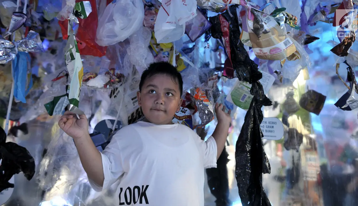 Seorang anak mengunjungi instalasi sampah plastik di dalam 'perut' paus sperma yang mati di Wakatobi ketika Gerakan Indonesia Bersih di Bundaran HI, Jakarta, Minggu (28/4/2019).  Kegiatan itu untuk mengedukasi masyarakat akan bahaya pencemaran sampah plastik di laut. (merdeka.com/Iqbal S. Nugroho)