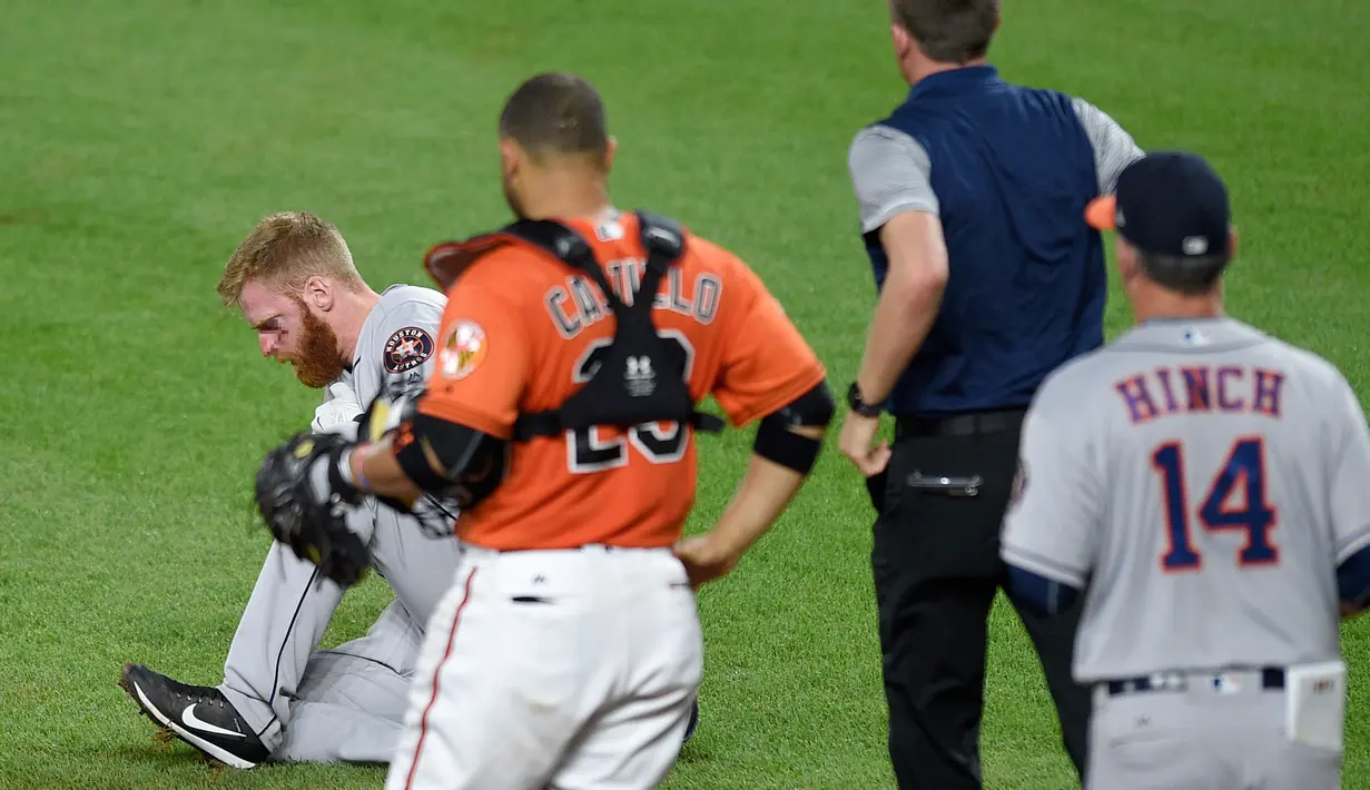 Pemain Houston Astros, Colin Moran kesakitan setelah bola menghantam matanya saat bertanding pada pertandingan bisbol melawan Baltimore Orioles di Oriole Park di Camden Yards di Baltimore, Maryland (22/7). (AP Photo/Nick Wass)