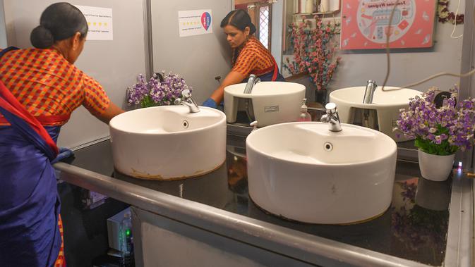 Foto pada 9 Februari 2020 menunjukkan petugas membersihkan bagian dalam toilet keliling di sebuah bus di taman umum di Pune, India. Proyek Ti Toilet, sebuah bus yang diubah menjadi toilet dan diluncurkan pada tahun 2016, adalah gagasan Ulka Sadalkar dan Rajeev Kheer. (Indranil MUKHERJEE/AFP)