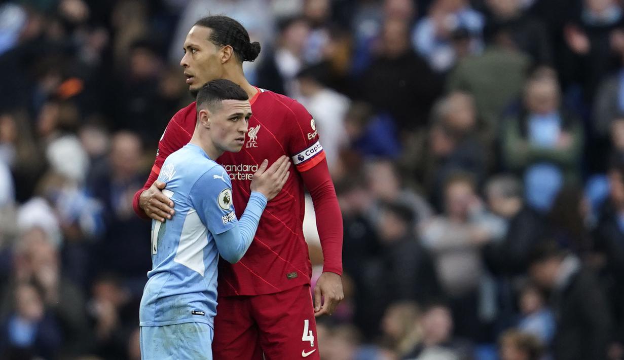 Pemain Liverpool, Virgil van Dijk (kanan) memeluk pemain Manchester City, Phil Foden pada akhir pertandingan Liga Inggris antara Manchester City dan Liverpool di Etihad Stadium, 10 April 2022. (AP/Jon Super )