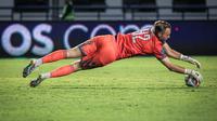 Kiper Dewa United, Sonny Stevens berusaha menangkap bola pada laga pekan ketiga BRI Liga 1 2023/2024 antara Persib Bandung melawan Dewa United di Stadion GBLA, Bandung, Jumat (14/07/2023). (Bola.com/Bagaskara Lazuardi)
