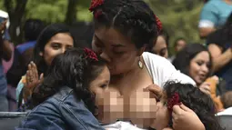 Ibu-ibu menyusui anak mereka selama festival menyusui "Big latch On" yang diadakan di Bonatic Garden of the Chapultepec Park di Mexico City, Meksiko (5/8). Festival ini bertujuan untuk mempromosikan dukungan menyusui secara global. (AFP Photo/Yuri Cotez)